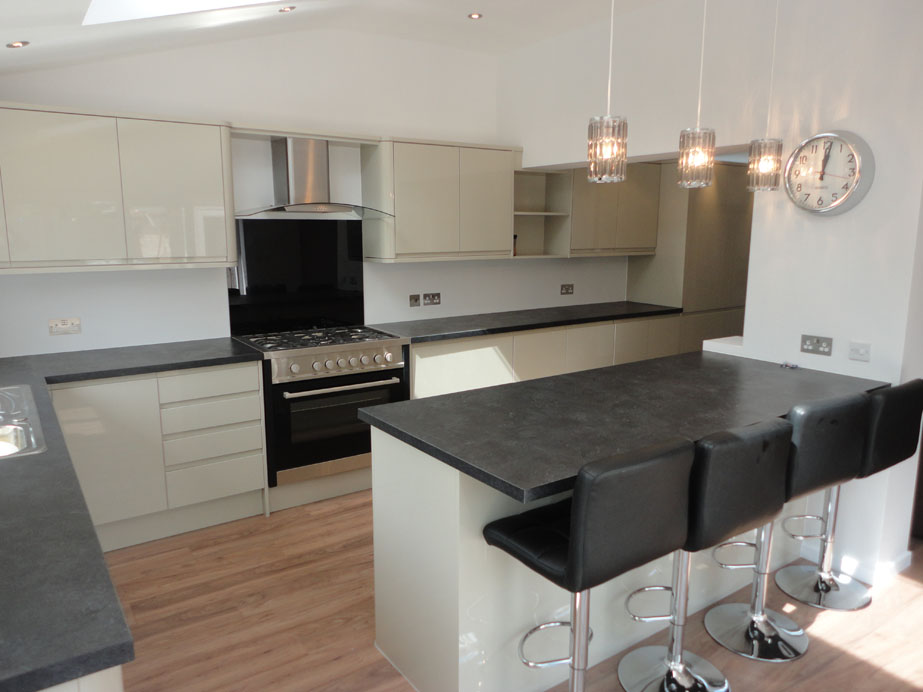 The reflective soft cream finish units contrast beautifully with the slate effect worktop & laminate flooring.