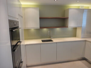 Granite worktop fitted with precision, completed with sleek glass splashback finish.